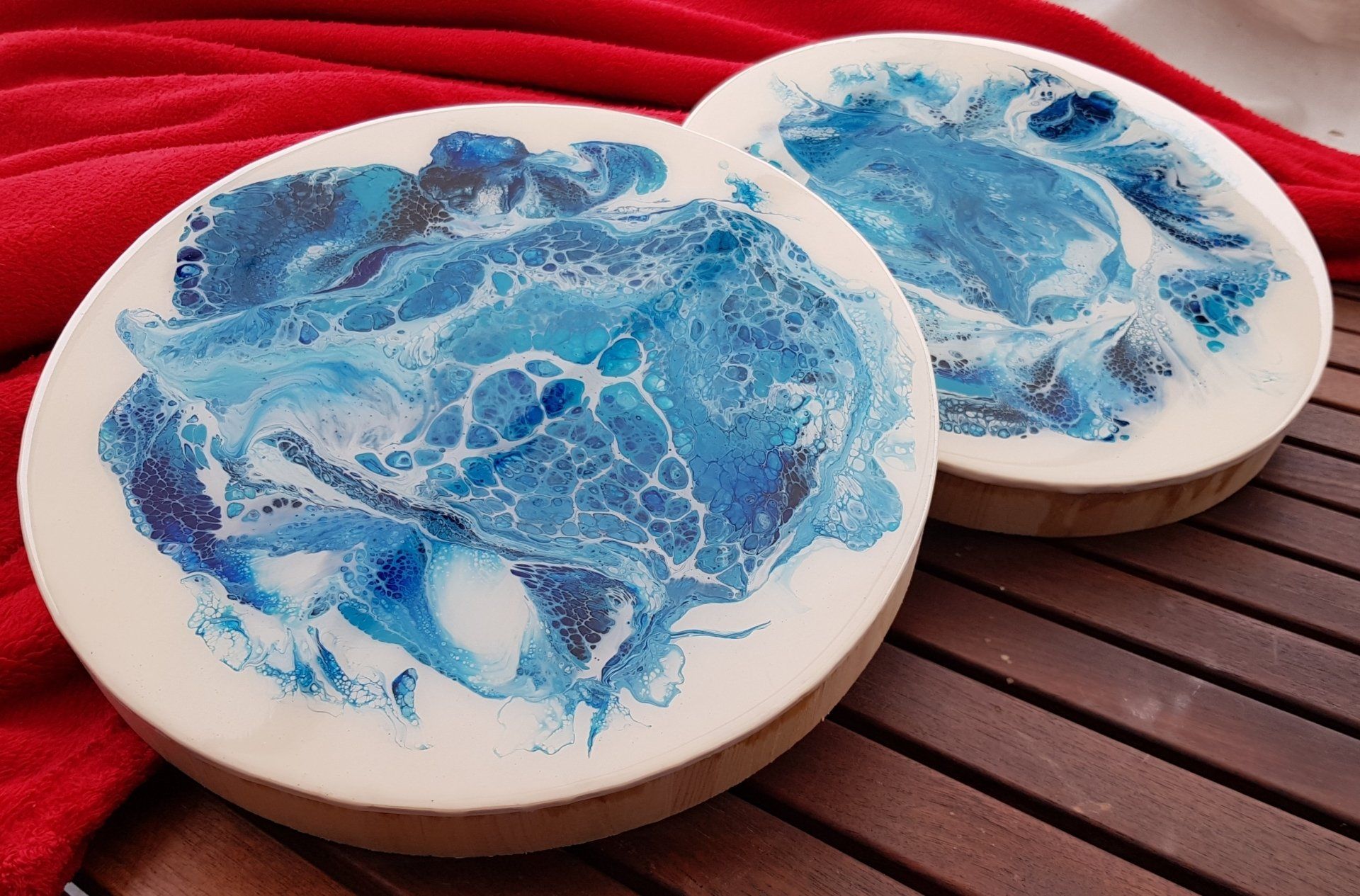 Twee blauw-witte onderzetters staan ​​op een houten tafel.