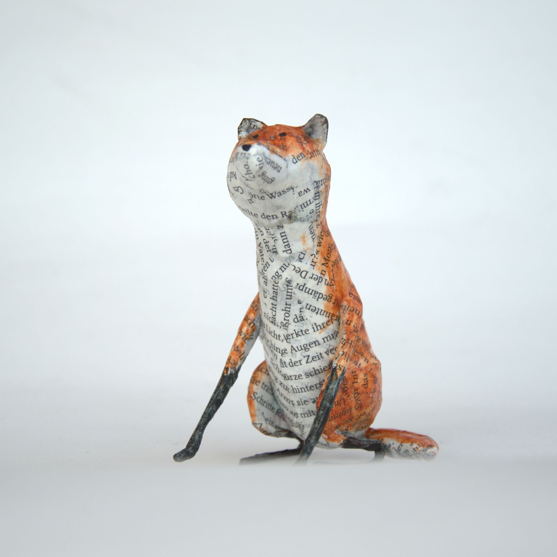 Een beeld van een vos zit op een wit oppervlak