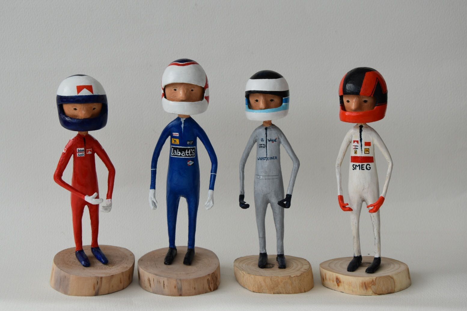 Vier beeldjes van autocoureurs staan ​​naast elkaar