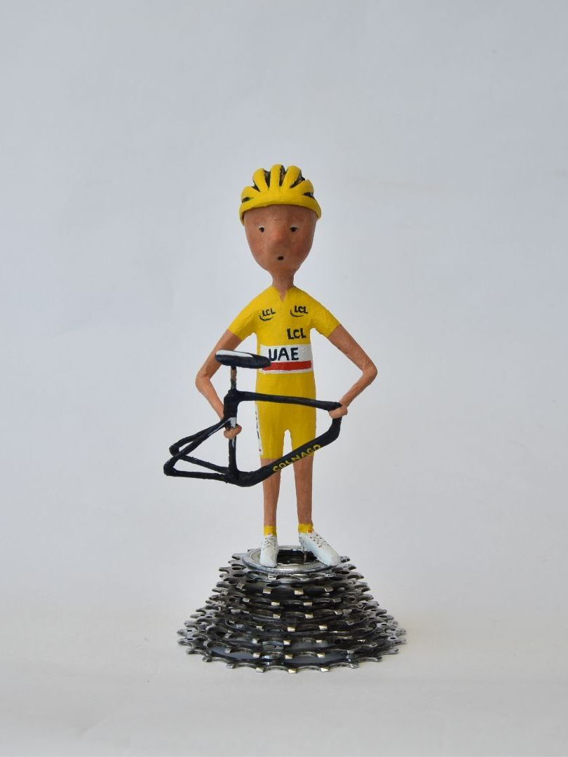 Een beeldje van een wielrenner die een fietsframe vasthoudt