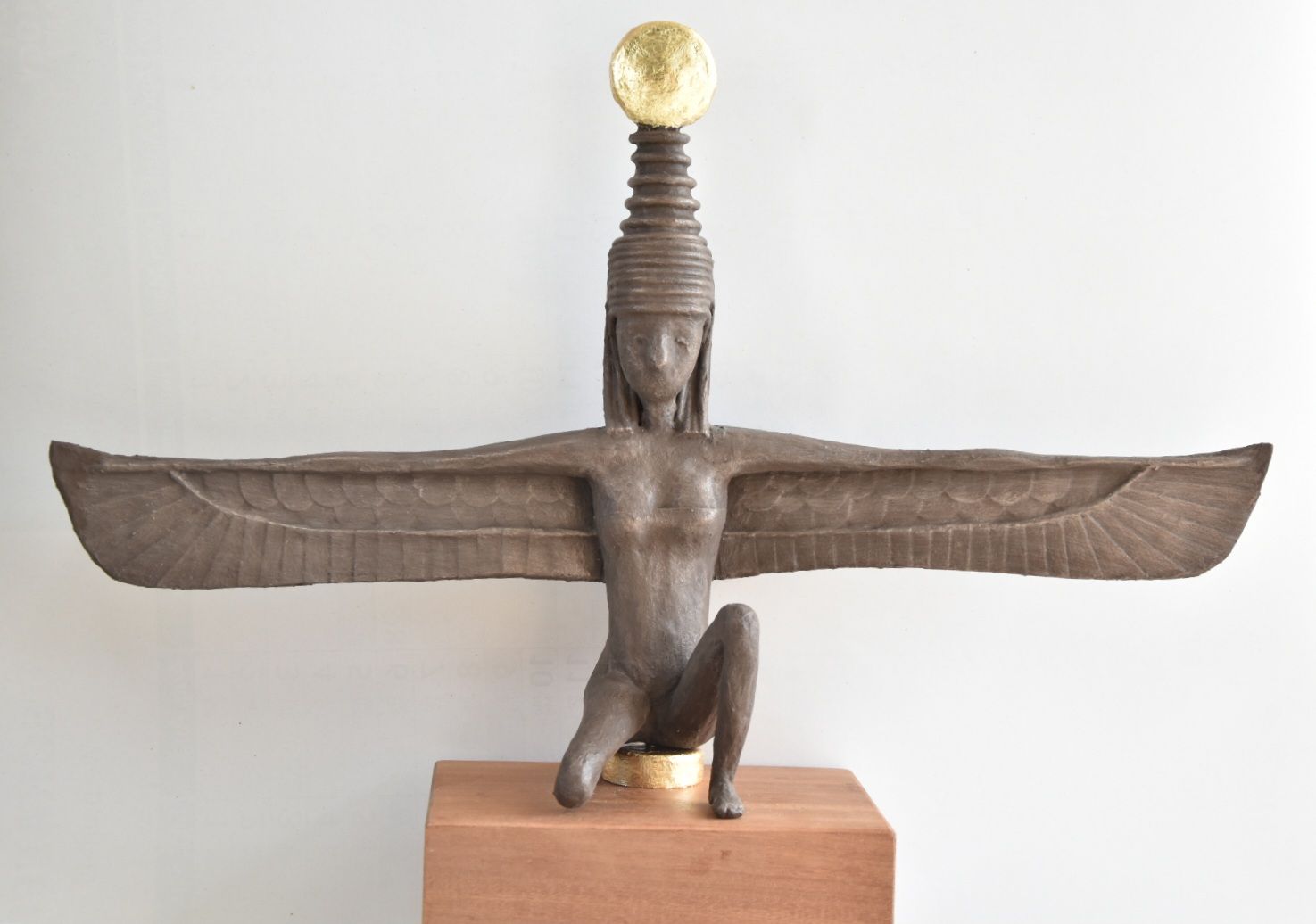 Isis beeld gemaakt van papier. Dit beeld heeft een bronzen afwerking en een bladgoud disk
