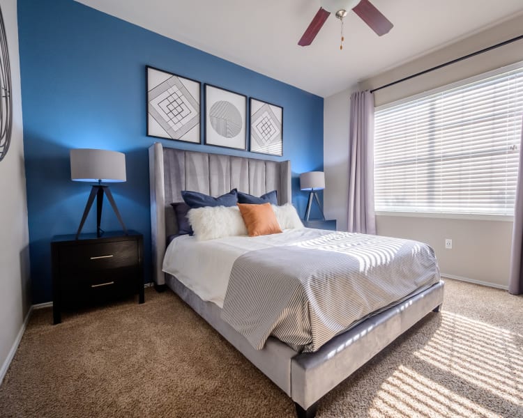 A bedroom with a bed , nightstand , lamps and a ceiling fan at 23Hundred Ridgeview.