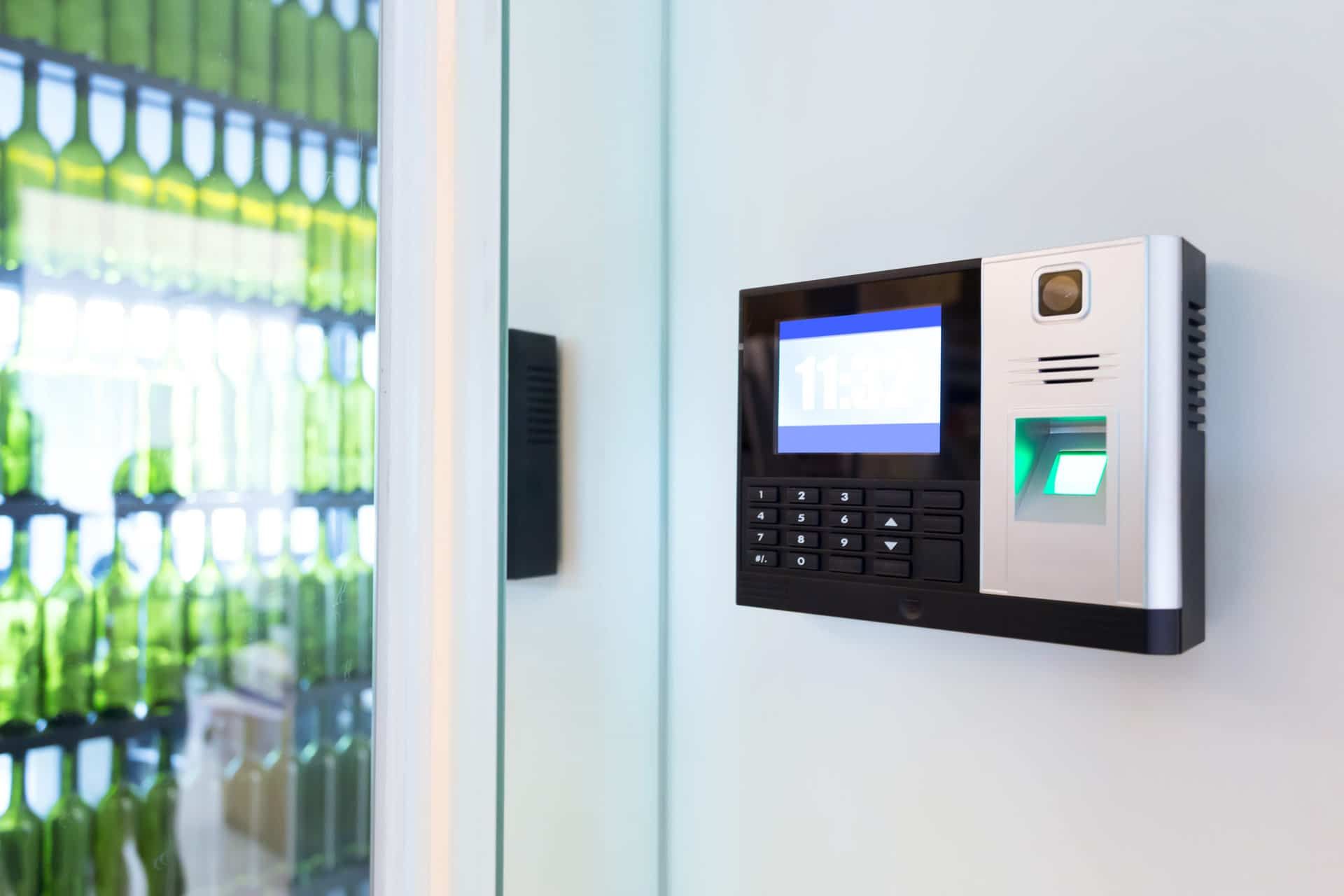 A Fingerprint Scanner Is Mounted On A Wall Next To A Glass Door — Eddie Williams Locksmiths in Cairns City, QLD