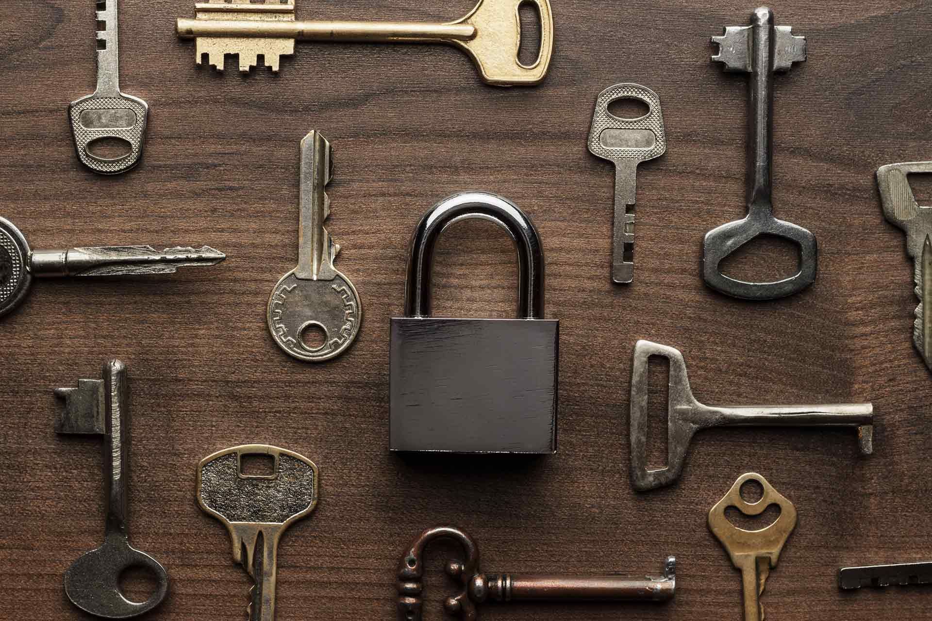 A Bunch Of Keys And A Padlock On A Wooden Table — Eddie Williams Locksmiths in Cairns City, QLD