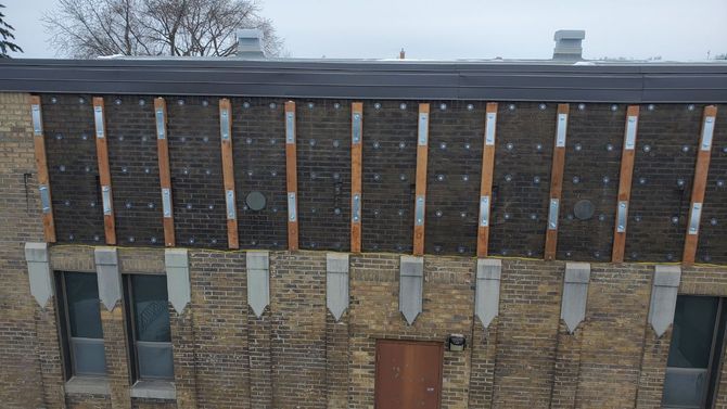 Une vue aérienne d'un bâtiment en briques avec un toit et une porte.