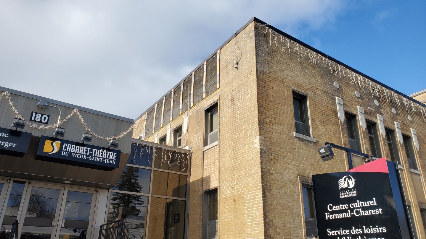 Un grand bâtiment en briques avec une enseigne sur le côté.