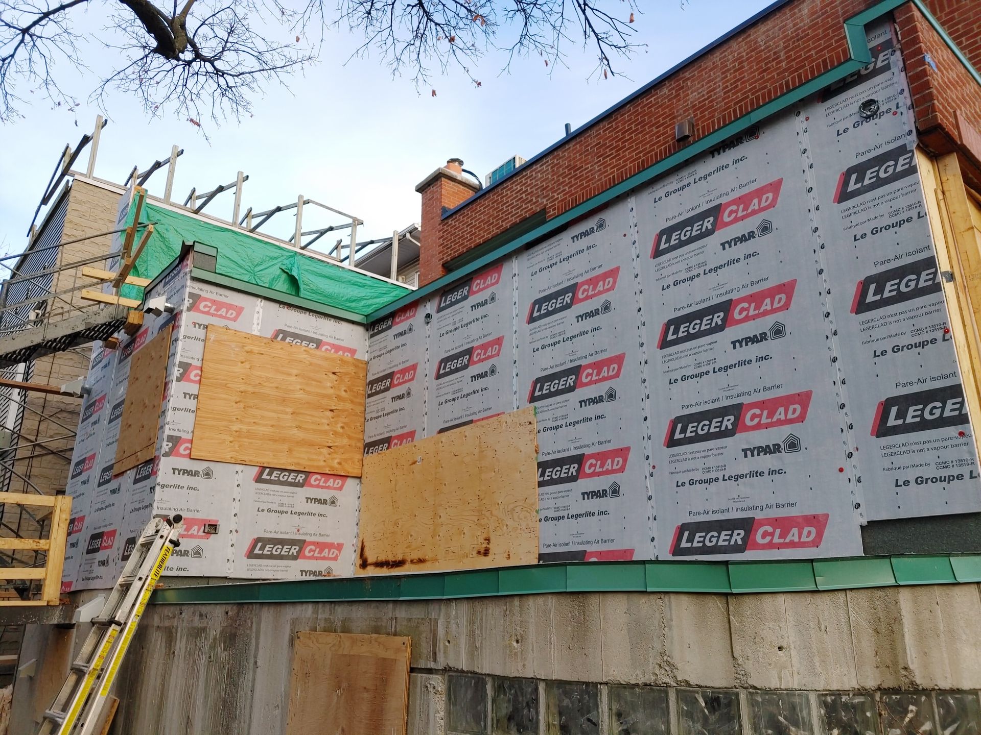 Une échelle est posée sur le côté d'un bâtiment en cours de rénovation.