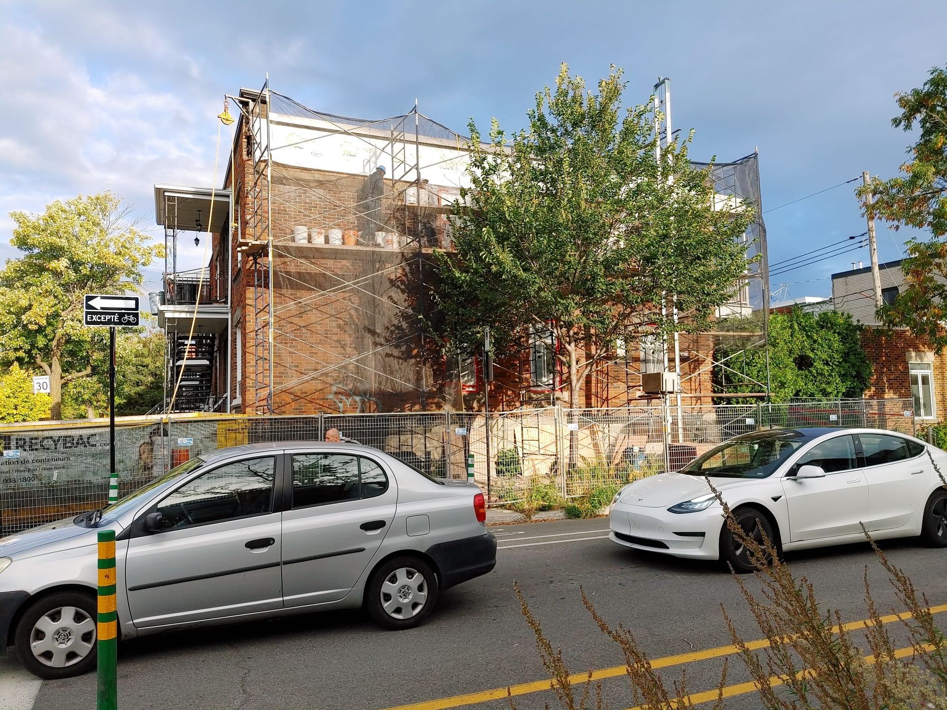 Une voiture argentée est garée sur le bord de la route à côté d'une voiture blanche.
