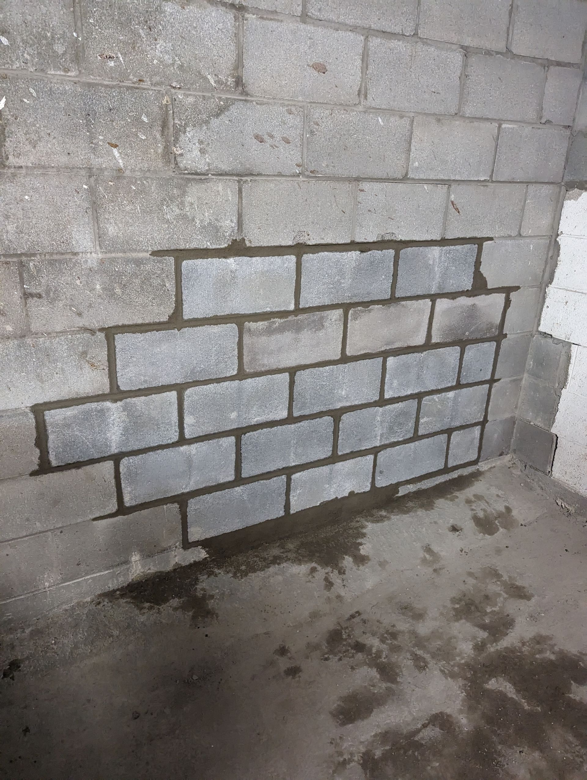 Un mur de briques est en train d'être construit dans un sous-sol.