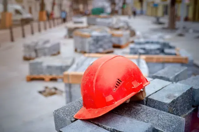 Un casque rouge est posé sur un tas de briques.