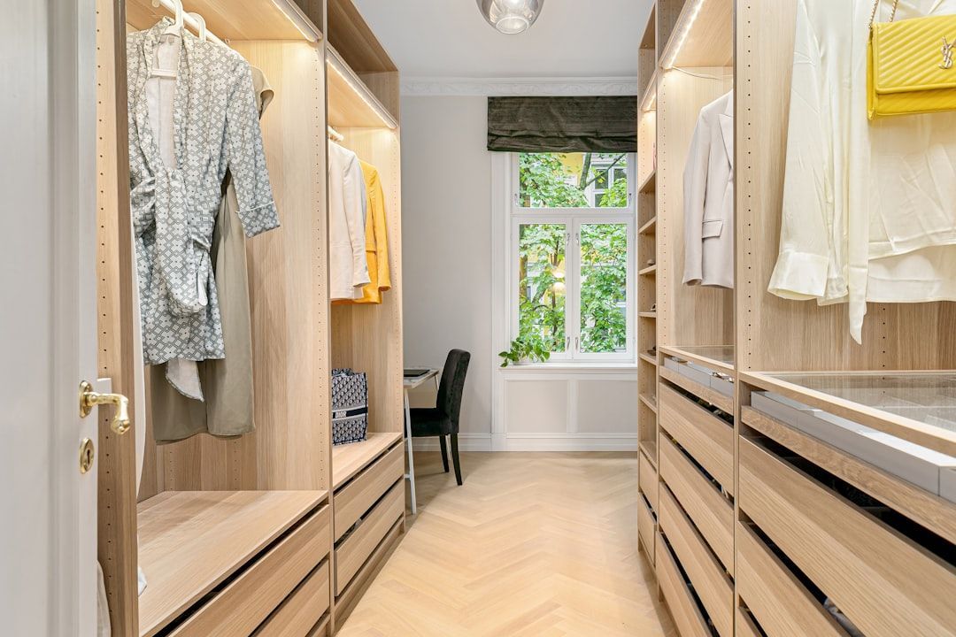 A happy homeowner admiring their new, beautifully organized custom closet space, smiling - custom closet cabinetry