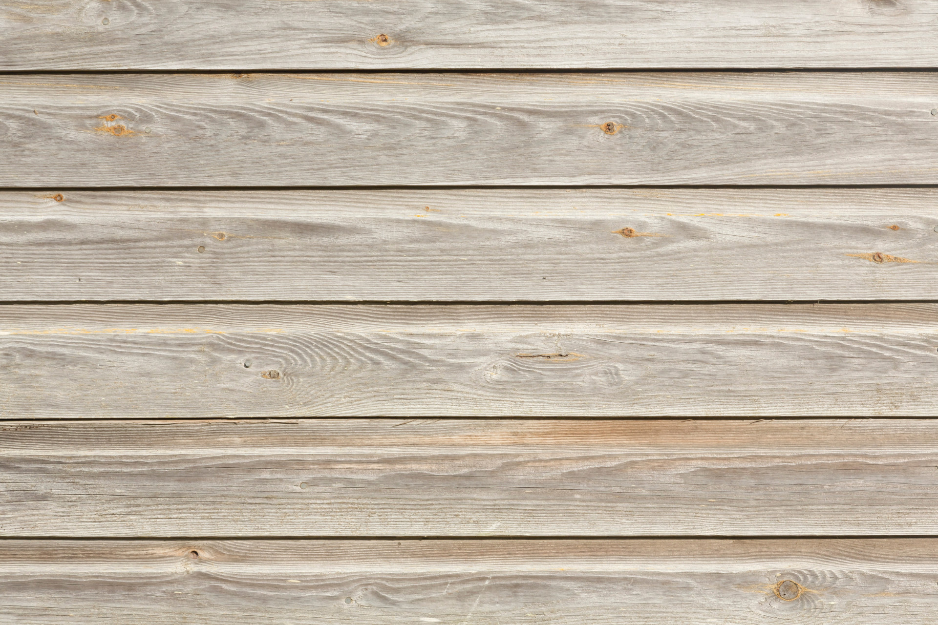 A close up of a wooden wall with a gray wood grain texture.