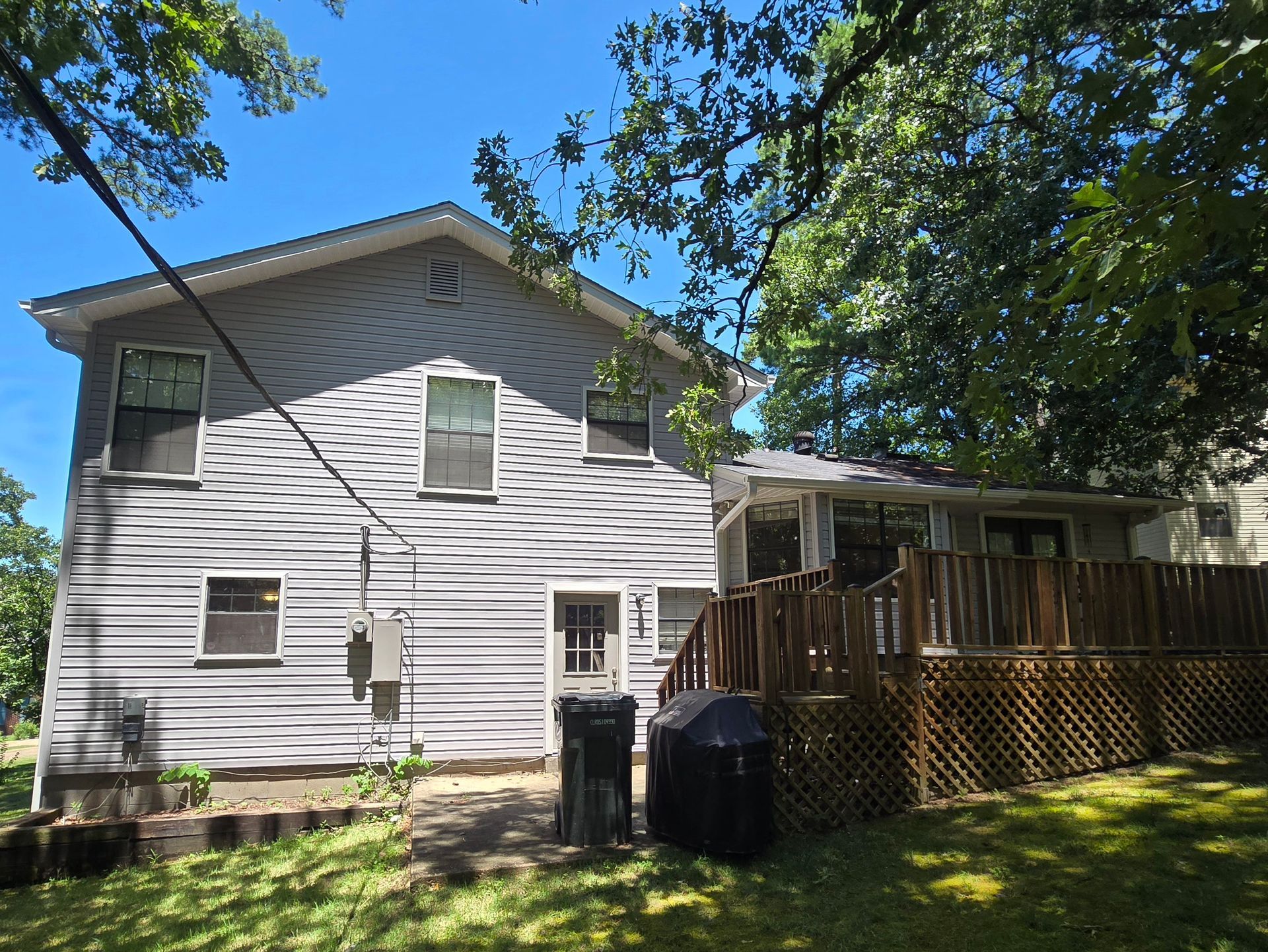 Mastic Carvedwood44 Dutchlap vinyl siding in Victorian Grey. 5” seamless gutters, downspouts, and all trim in Linen. window shutters in black