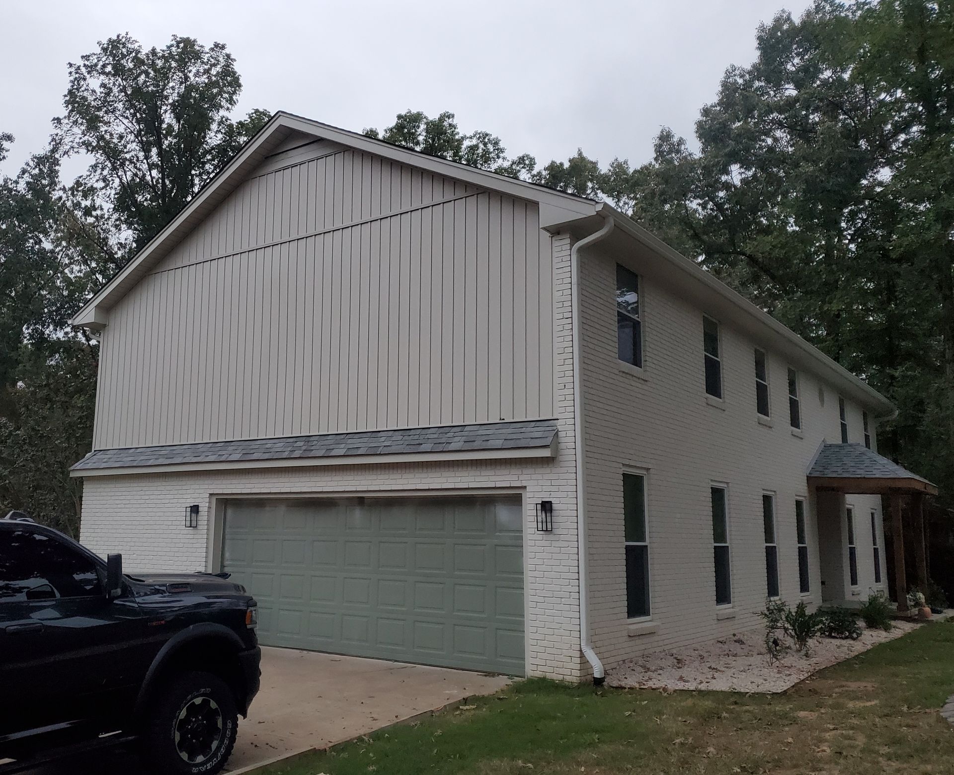 Exterior Portfolio Board & Batten vinyl siding in Bone. 5” seamless gutters, downspouts, and all trim in Linen