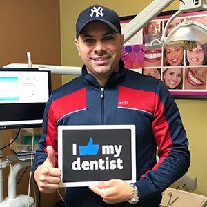 Man wearing a Yankees hat and zip-up jacket holding