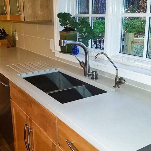 A concrete kitchen sink with a window in the background