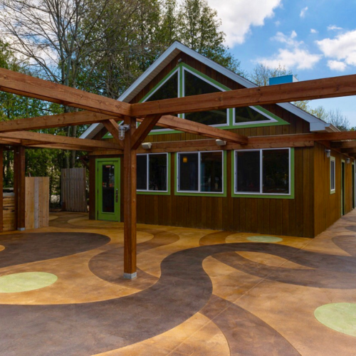 A house with a green door, a wooden roof and a stained concrete patio.