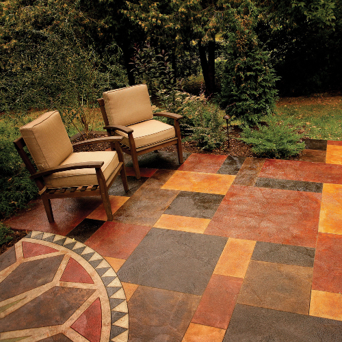 A stained concrete patio with two chairs and a circular table