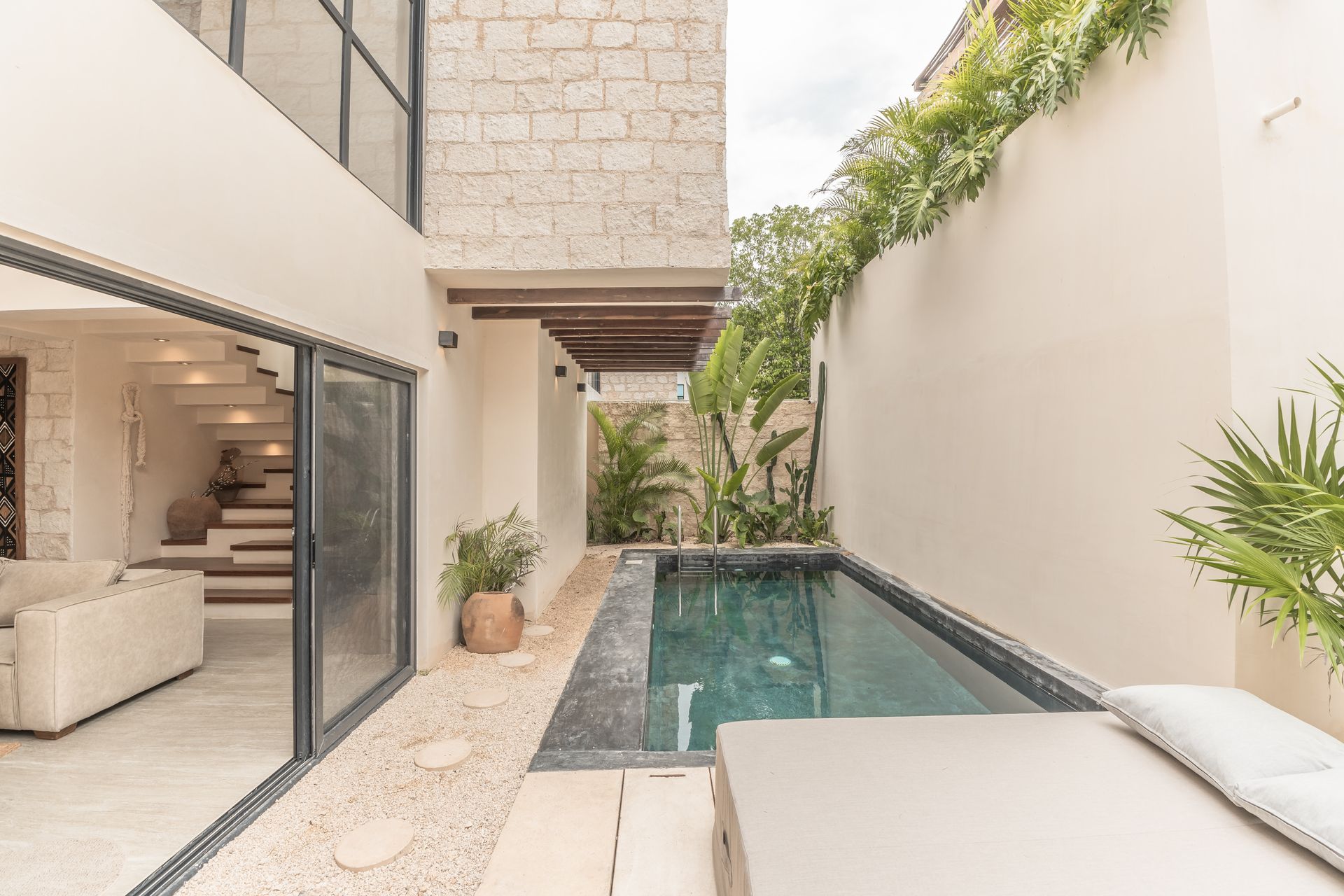 There is a swimming pool in the backyard of a house.