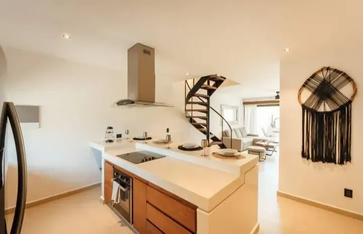 A kitchen with a spiral staircase leading to the second floor.