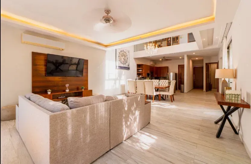 A living room with a large couch and a flat screen tv.