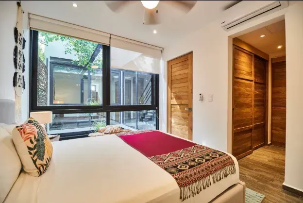 A bedroom with a large bed and a ceiling fan