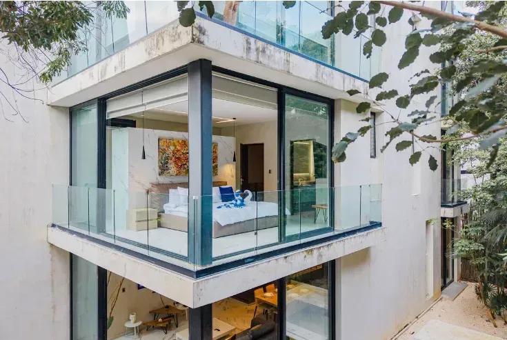 A modern house with a balcony and lots of windows.