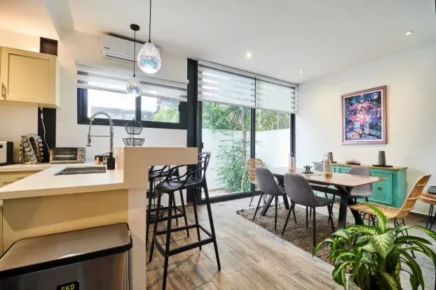 A kitchen and dining room in a house with a table and chairs.