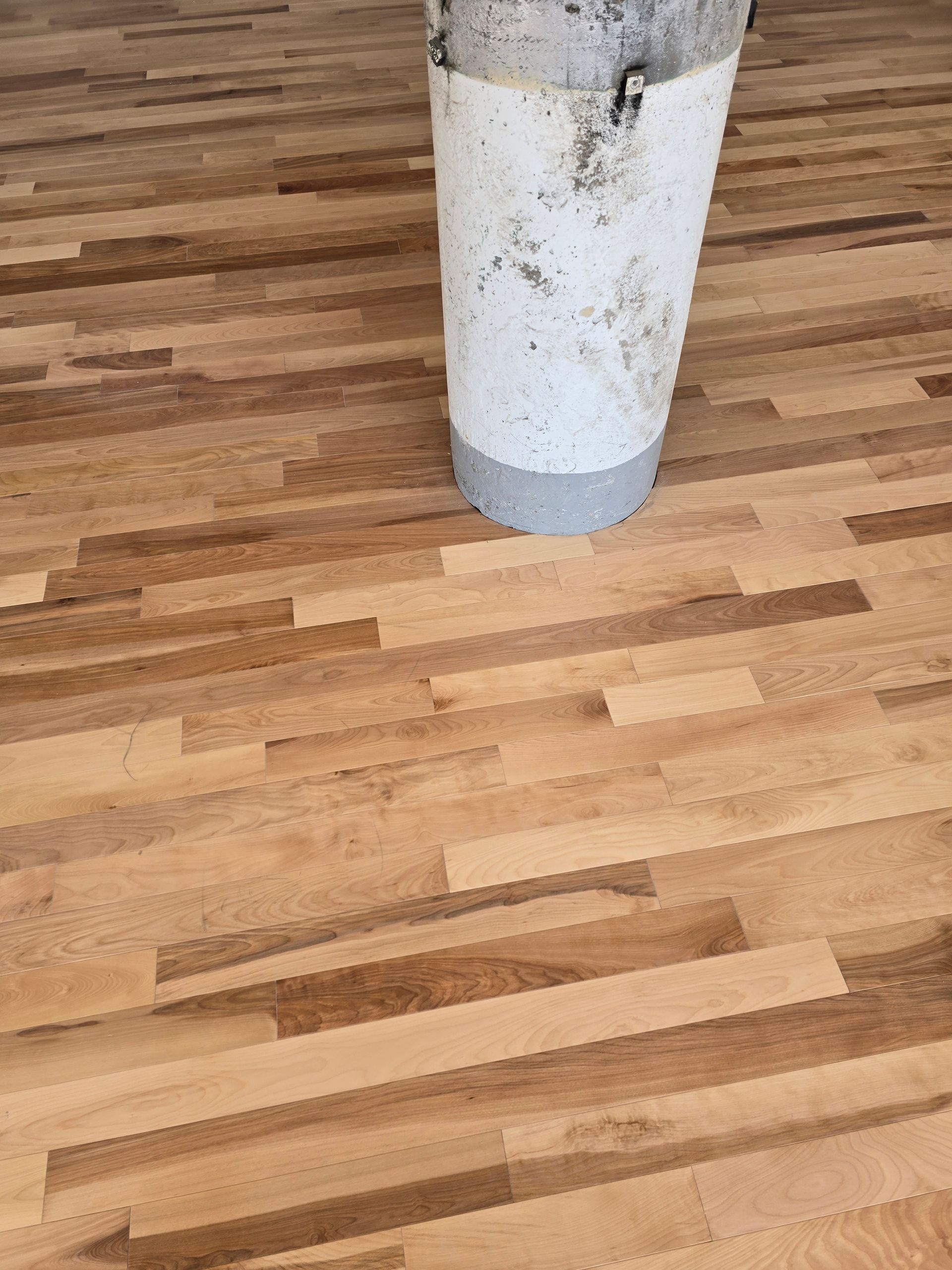 Un plancher en bois avec un seau blanc dessus