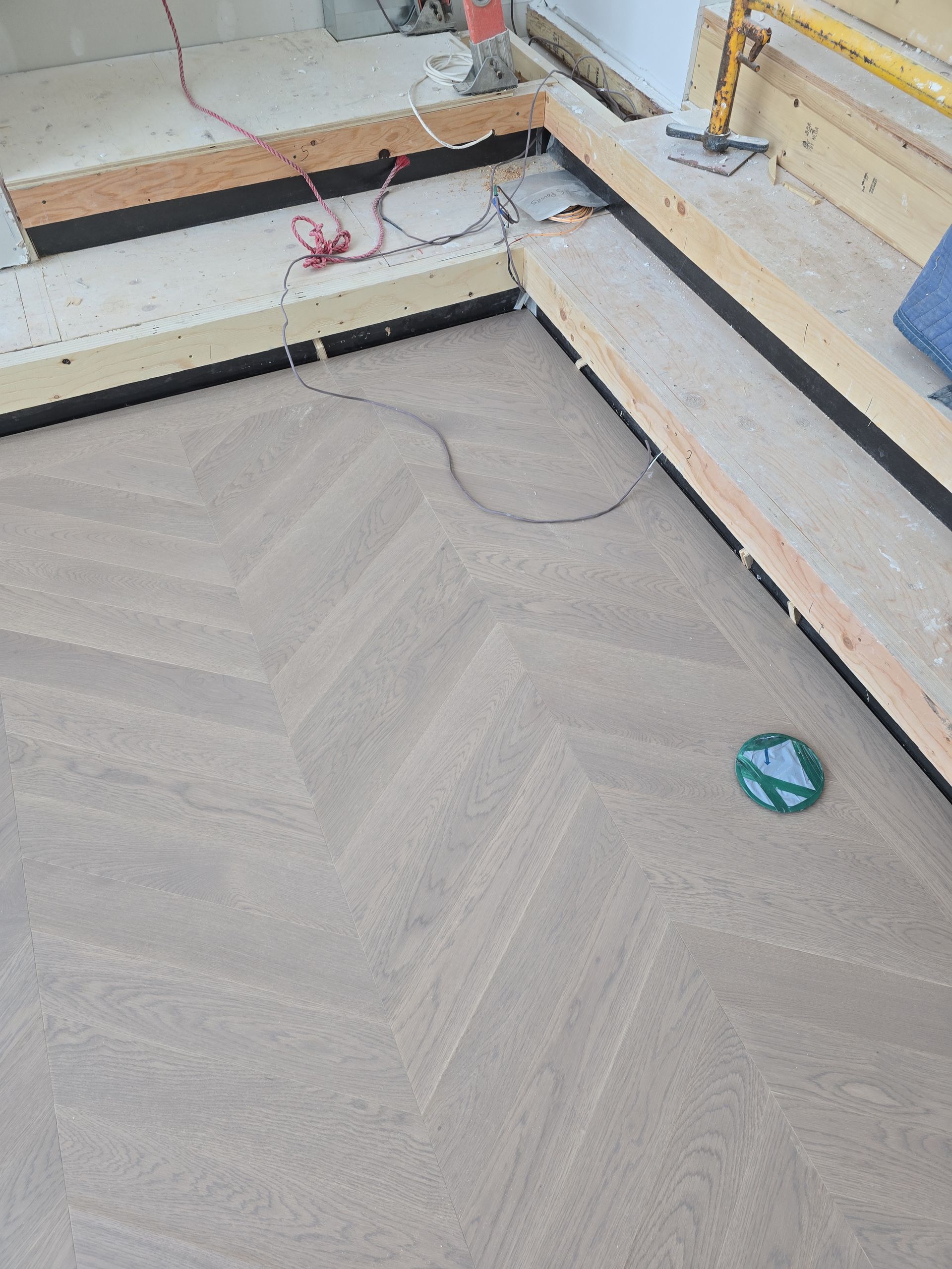 Un sol recouvert de moquette à chevrons dans une pièce en construction