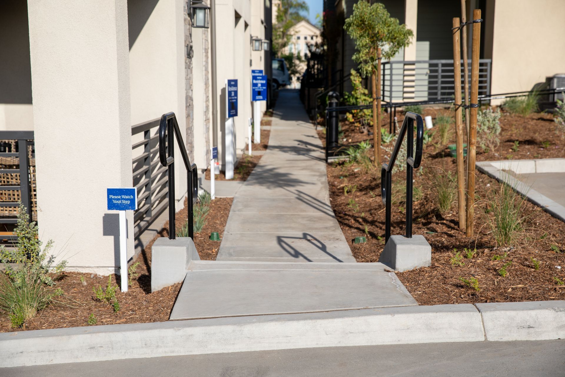 A concrete walkway leading to a building with stairs