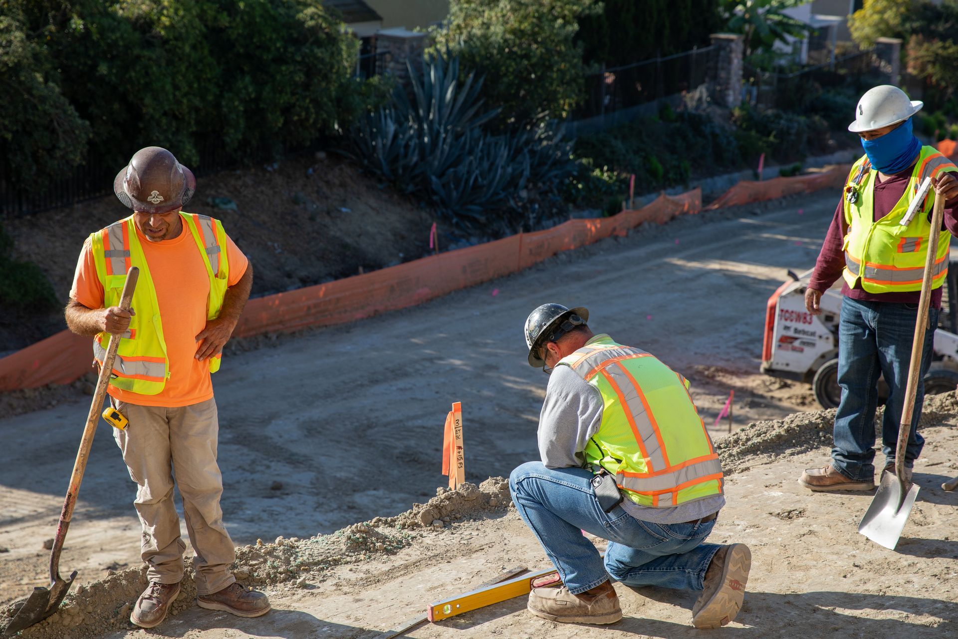 A group of construction workers are working on a road.