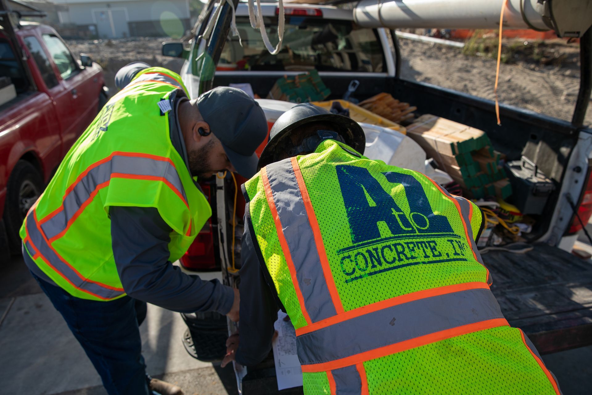 Two construction workers are working in the back of a truck.