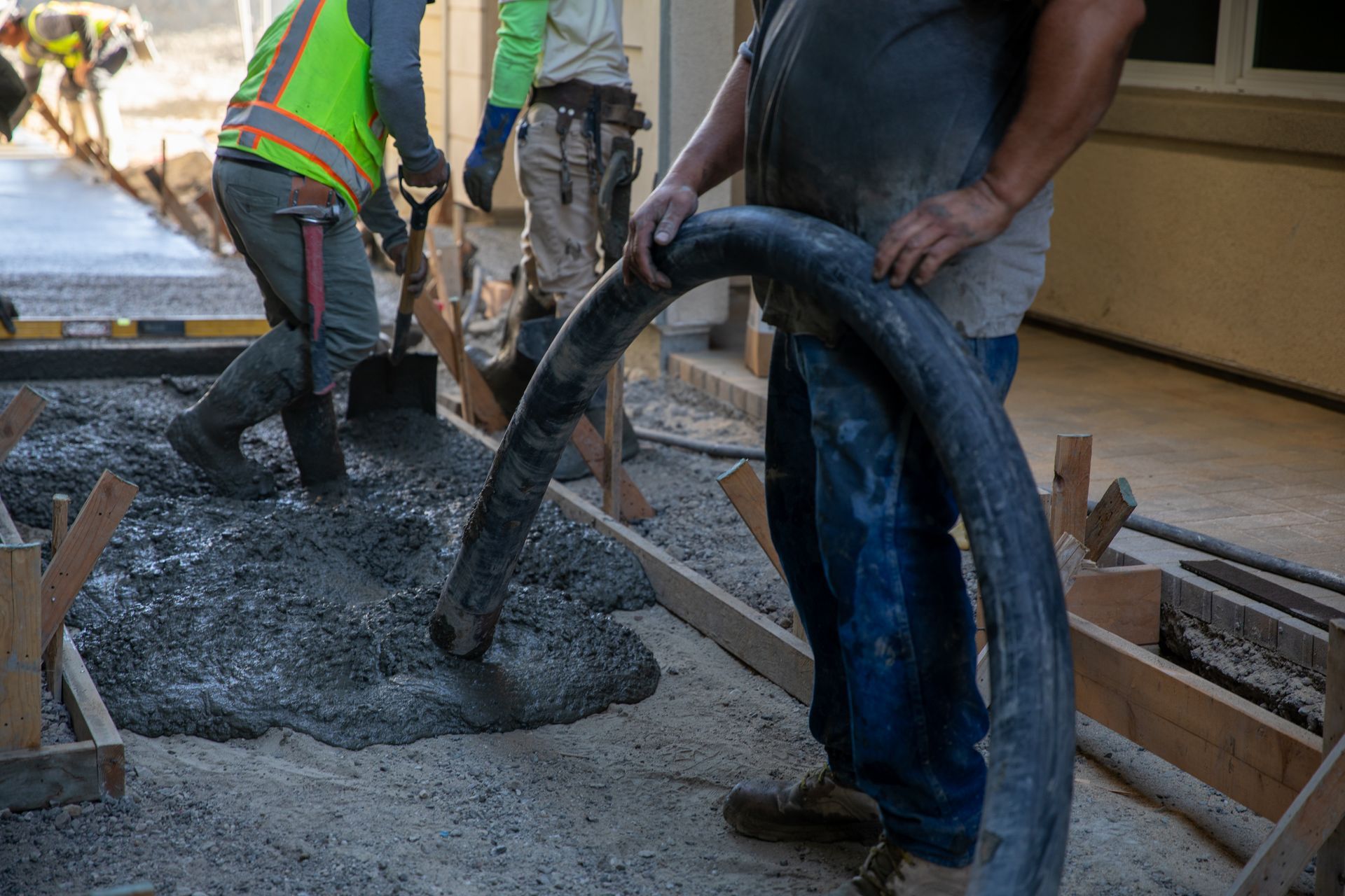 A group of construction workers are working on a concrete floor.