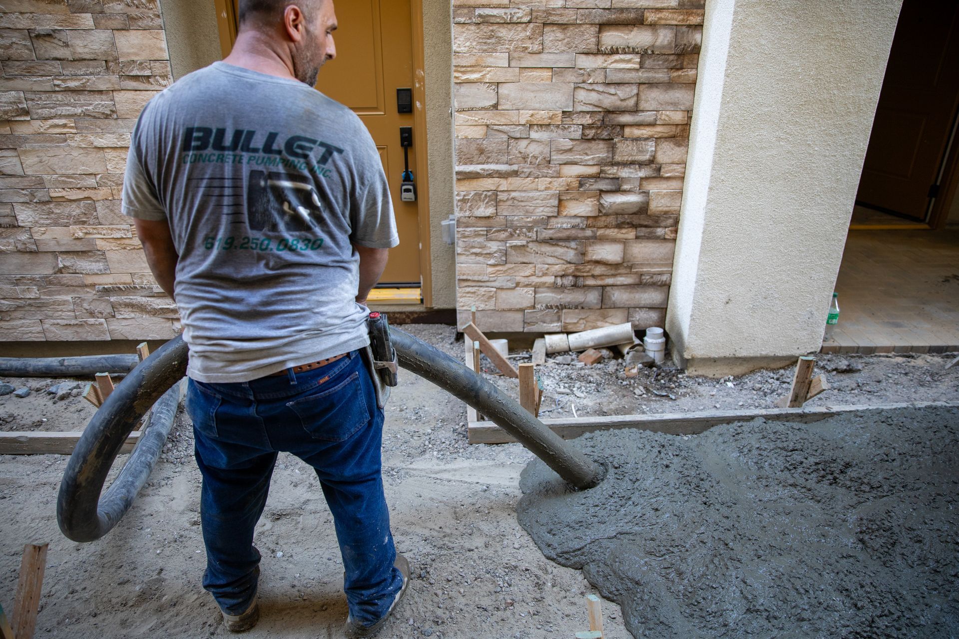 A construction worker lays concrete to make a sidewalk