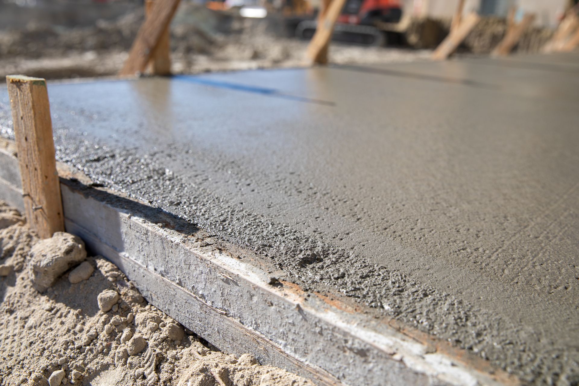 A close up of a concrete slab being poured on a construction site.