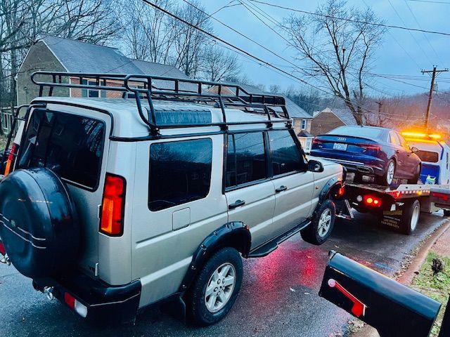 A car is being towed by a tow truck.