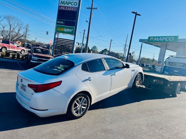 A white car is being towed by a tow truck.