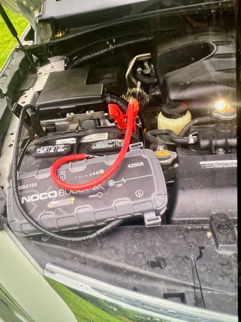 The hood of a car with a noco battery attached to it