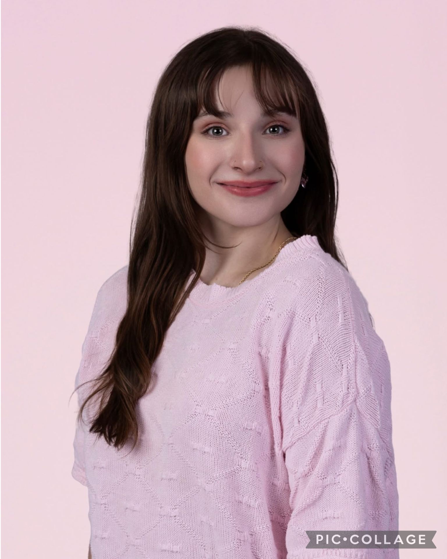 A woman is smiling while sitting in the back seat of a car.