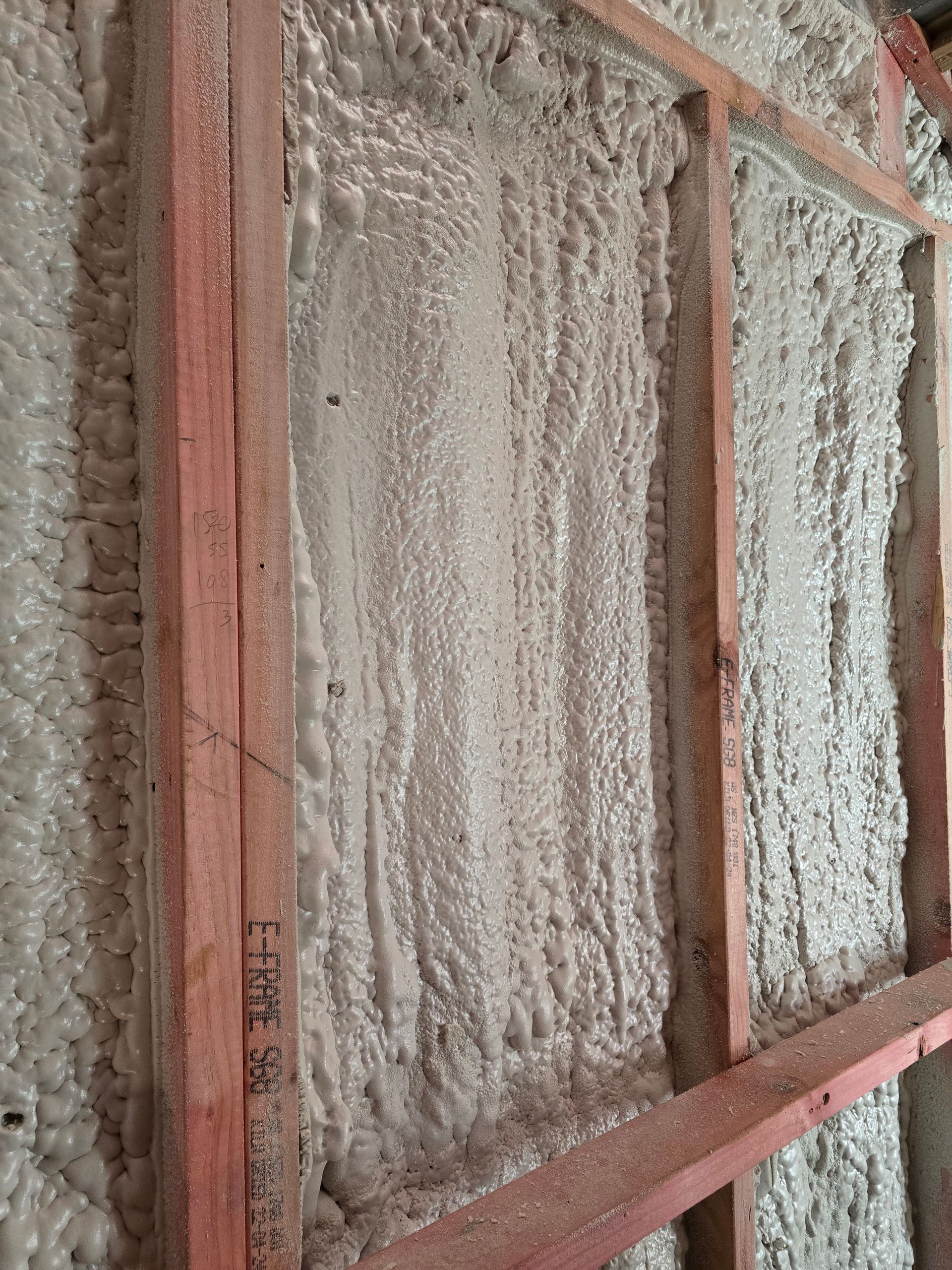 A close up of a wall with foam on it and a wooden frame.