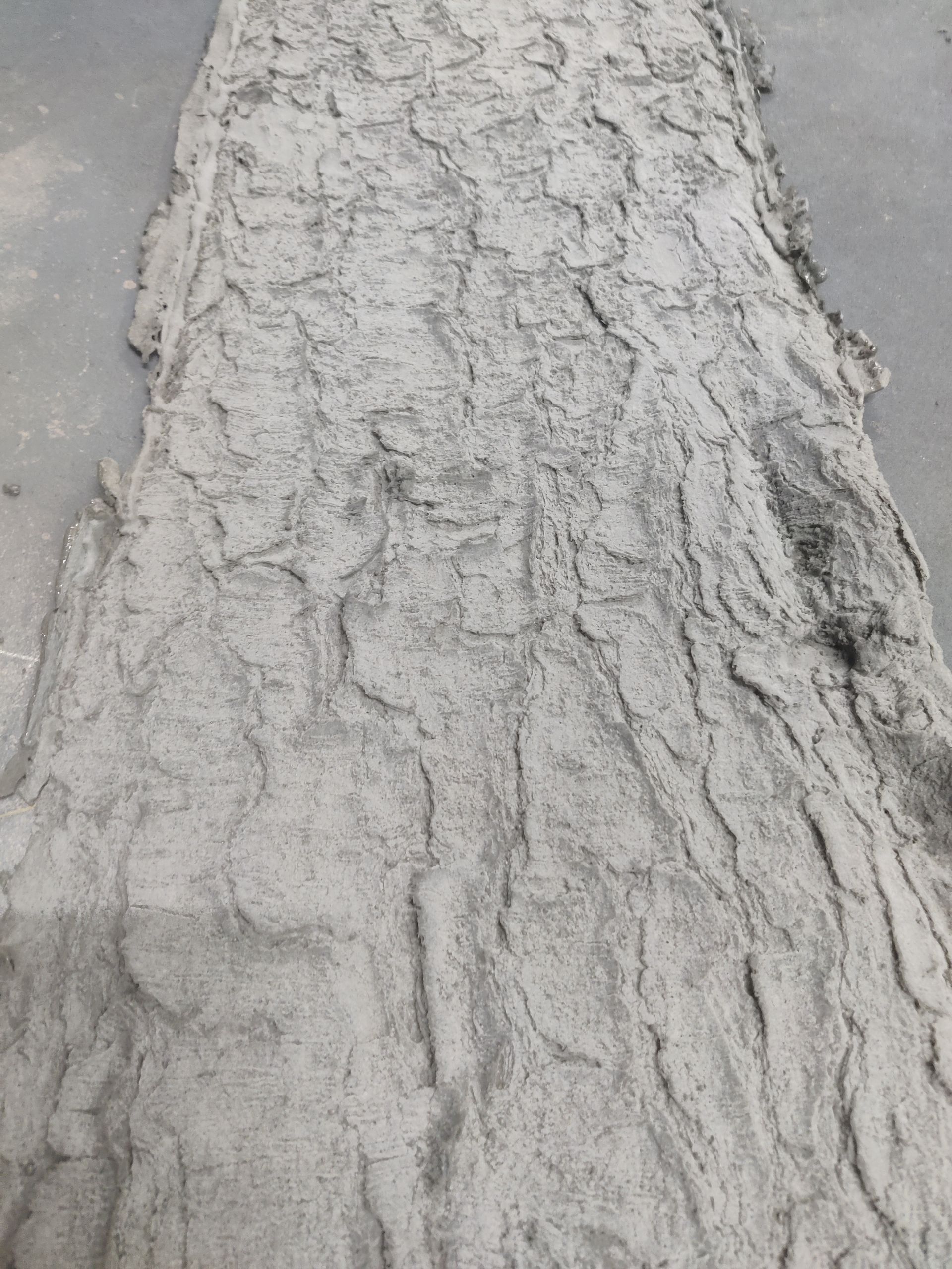 A black and white photo of a tree trunk covered in sand.