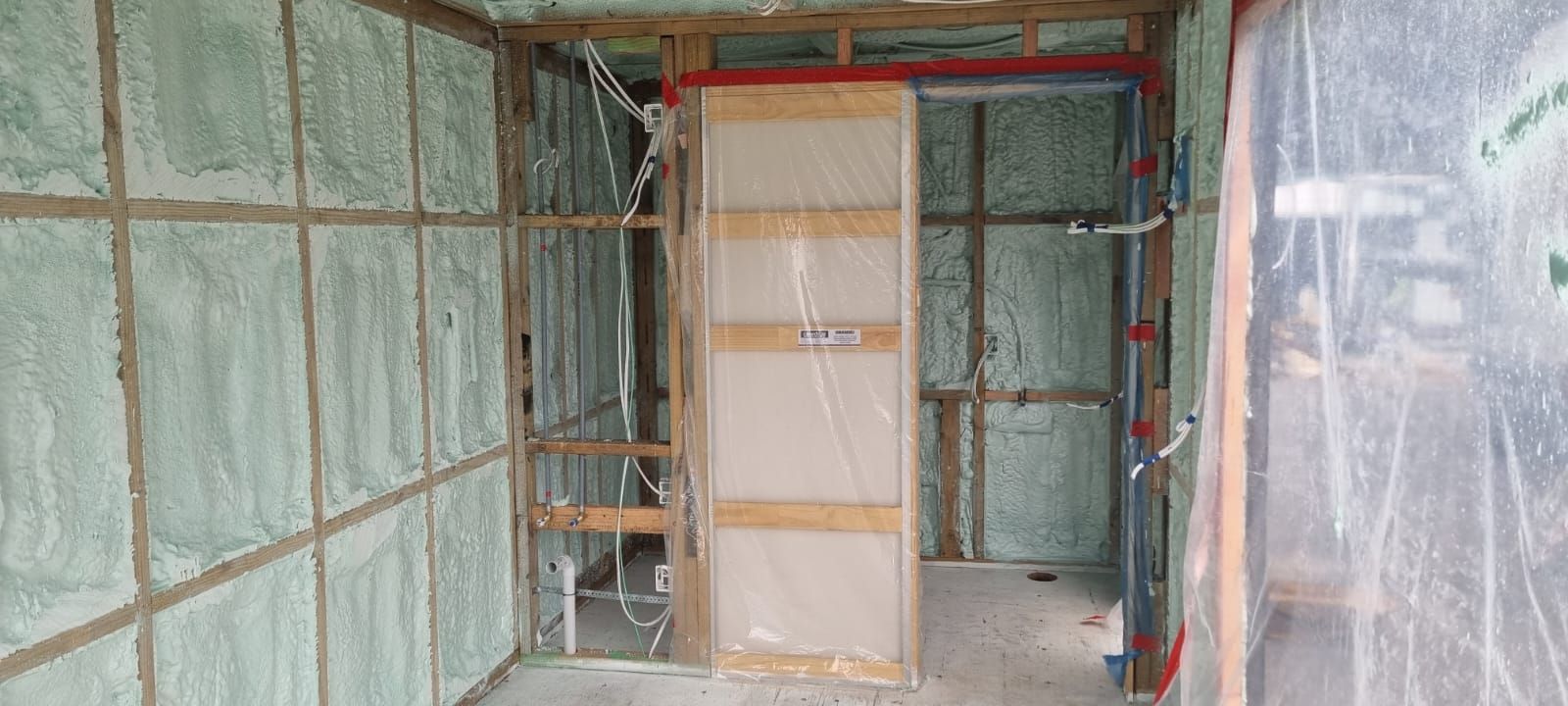 A room with foam insulation on the walls and a sliding door.