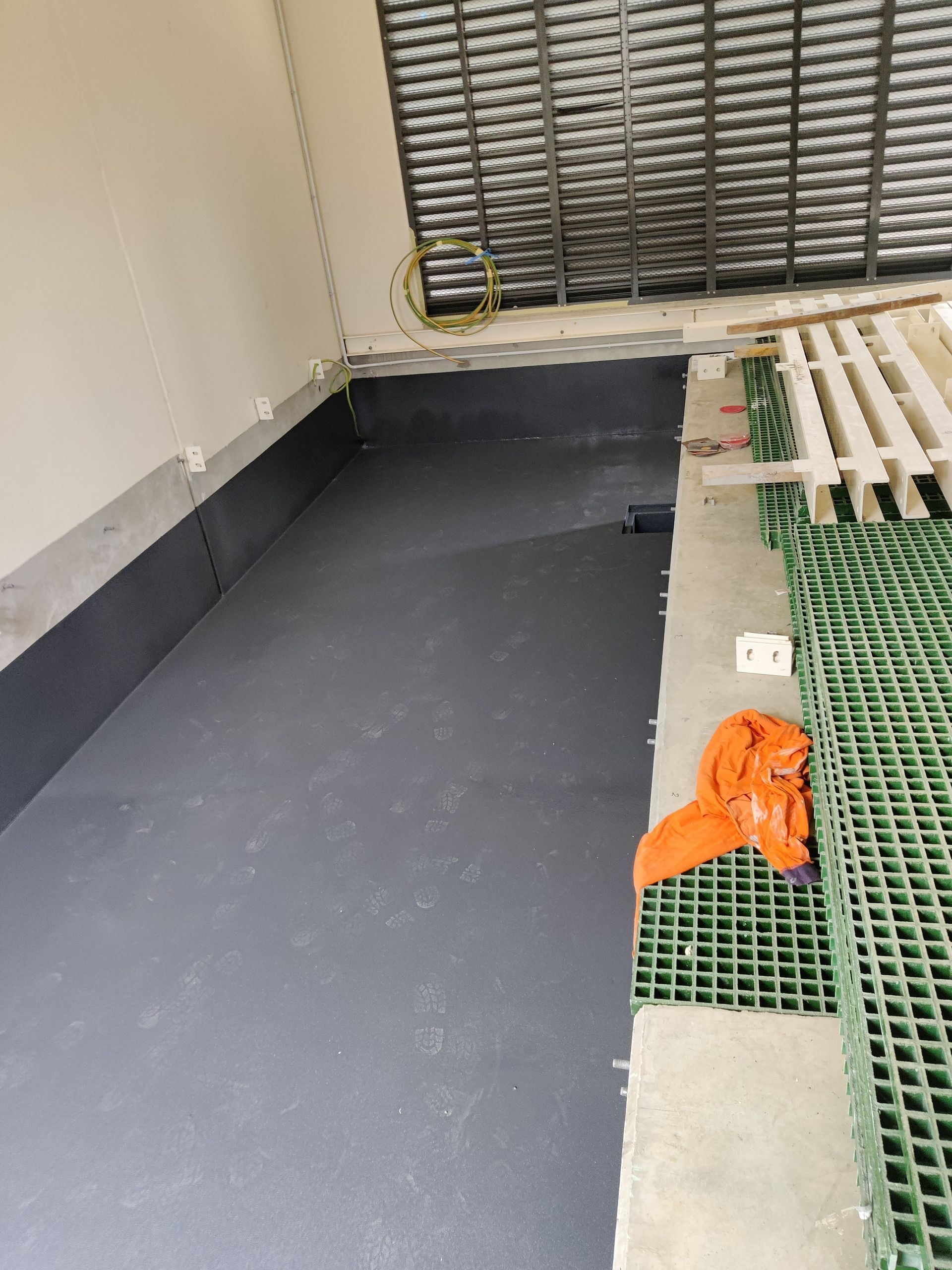 A room with a black floor and a green grid on the floor.