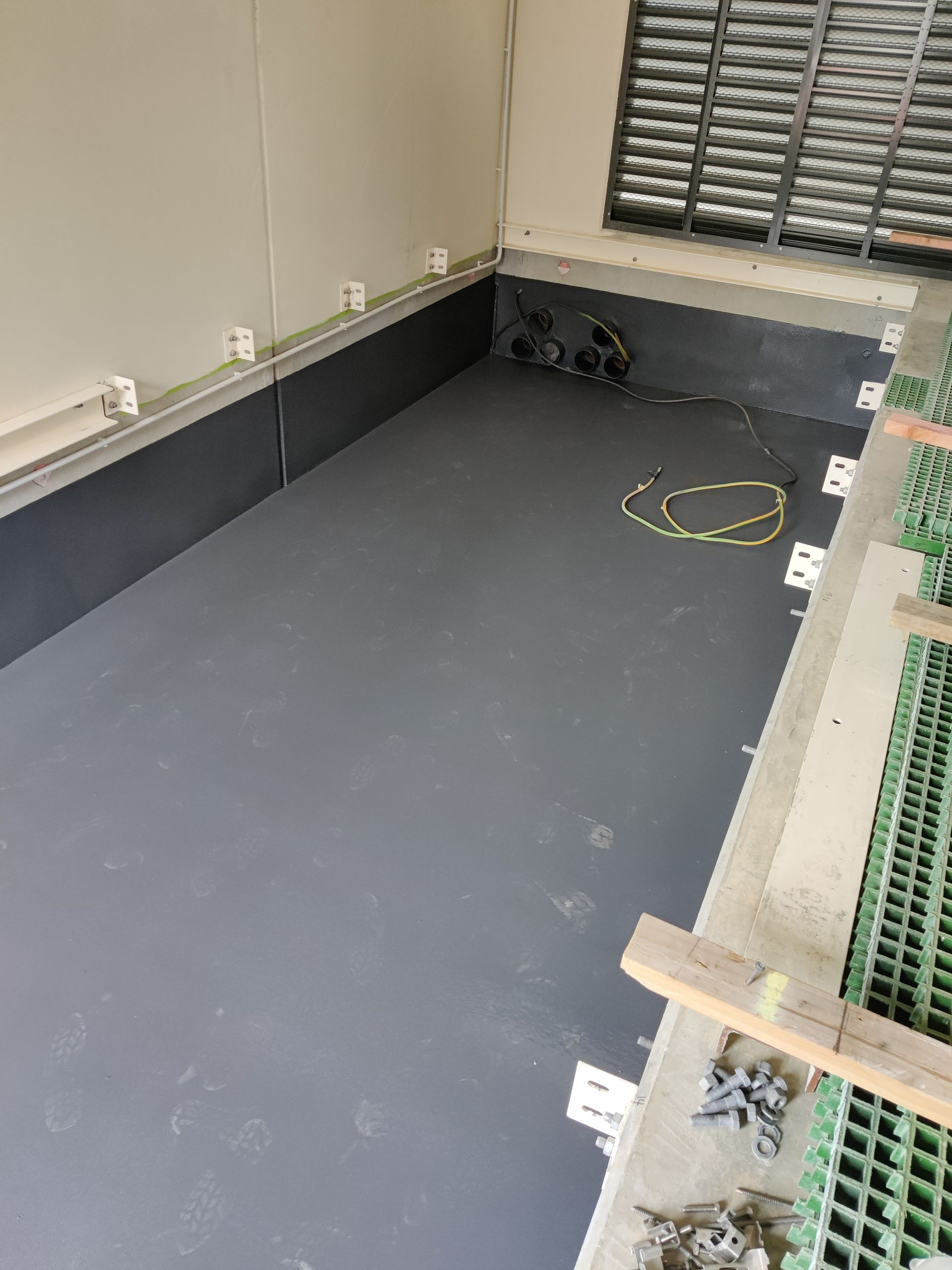 A room with a gray floor and a window.