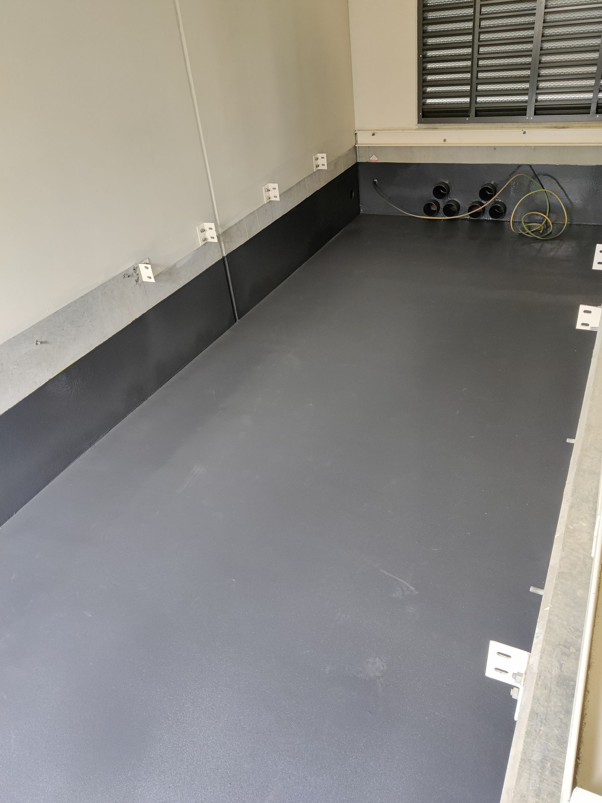 A room with a gray floor and a window.