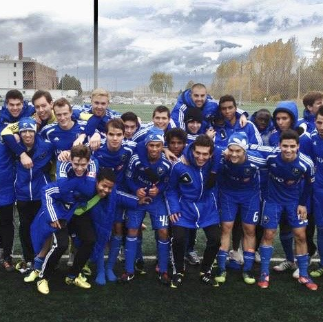 A group of soccer players posing for a picture on a field