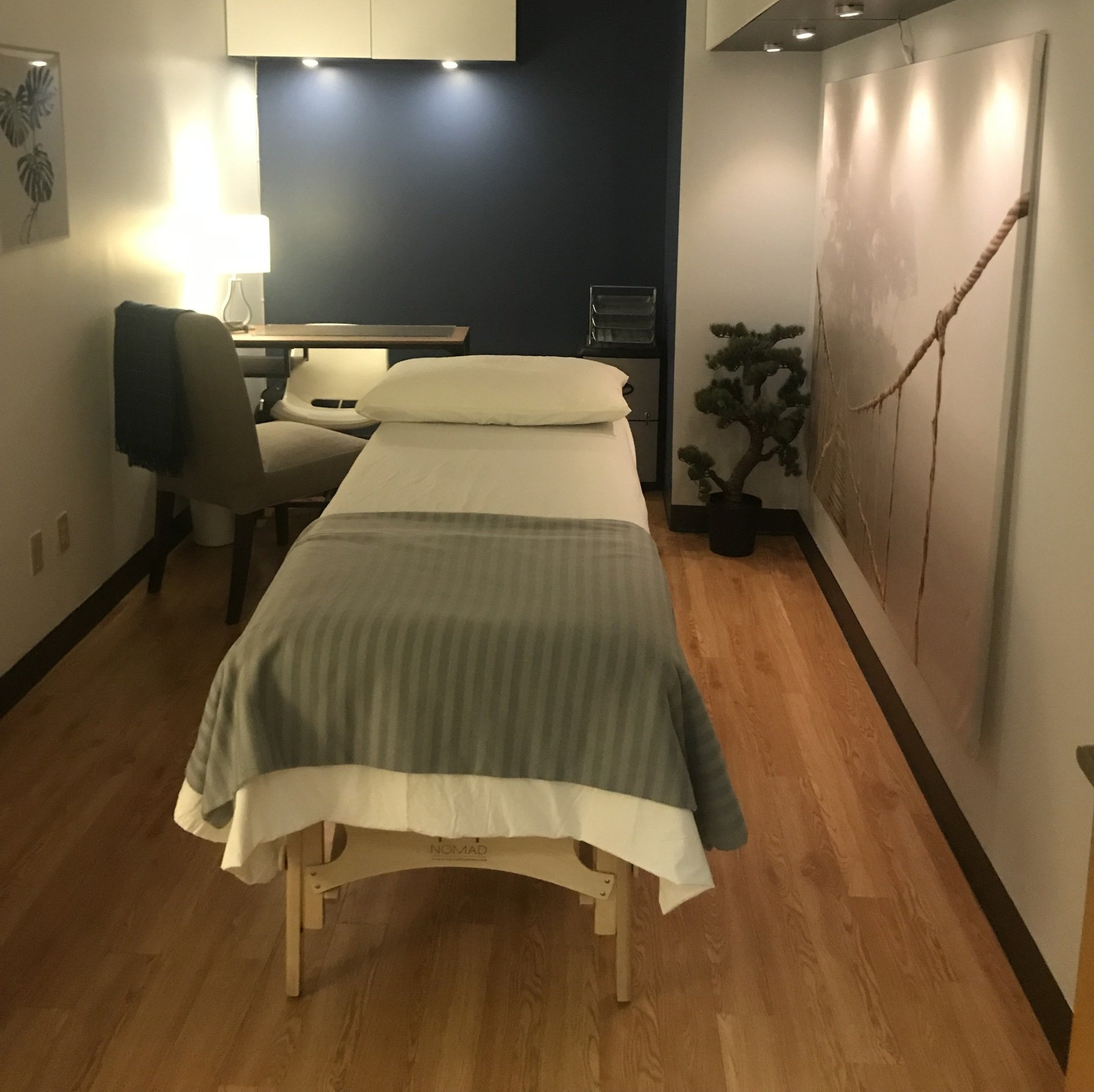 A massage table in a room with a chair