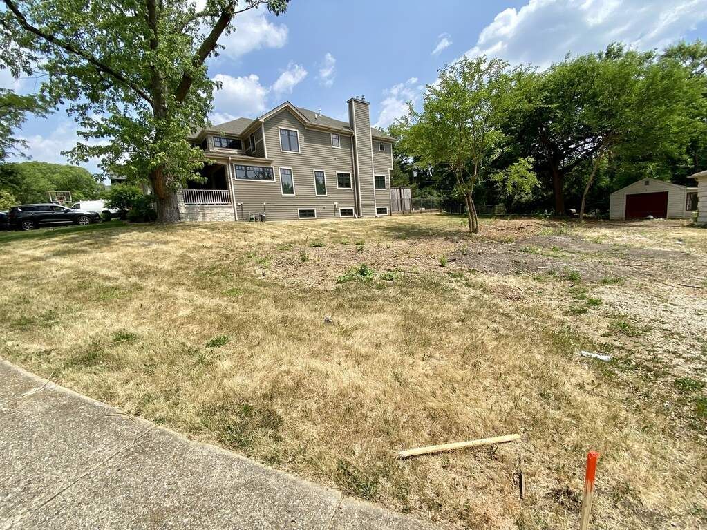 A large house is sitting on top of a grassy hill.