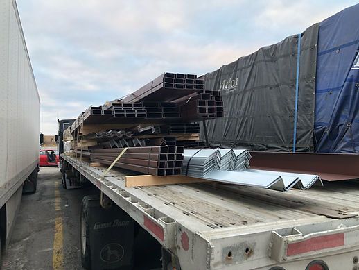 A semi truck is loaded with a lot of metal